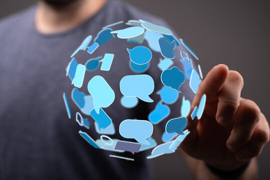Person interacting with a 3D sphere made of blue speech bubbles, conveying communication, networking and digital connection.
