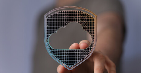 Abstract cloud security concept with a hand holding a digital cloud shield for data protection and safety.