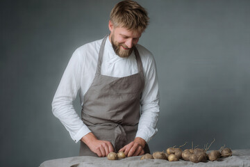 dedicated man in apron passionately creating unique culinary masterpieces against muted graybrown background