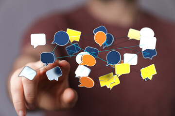 Hand pointing at colorful speech bubbles representing social media, communication, and networking, cloud comput