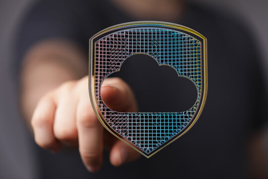 Concept of data protection and cloud computing security featuring a hand pointing to a shield-shaped cloud symbol.  Illustrates cyber