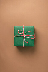 Christmas gift with a bow on a beige background, top view, minimalist, zero-waste concept