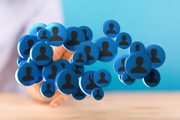 Digitally rendered image depicting a hand holding a network of connected human icons against a...