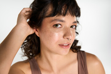 Fototapeta premium Young woman showcases trendy style in a bright, minimalist setting