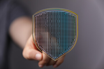 Abstract image of a hand holding a glowing digital shield, symbolizing cybersecurity, data protection, and secure network infrastruct
