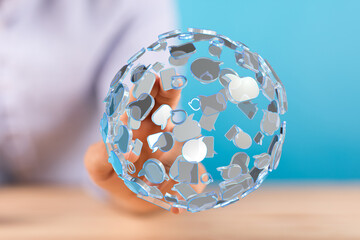 An abstract 3D globe made of speech bubbles is held by a person's hand. Represents communication, social media, global networking, an