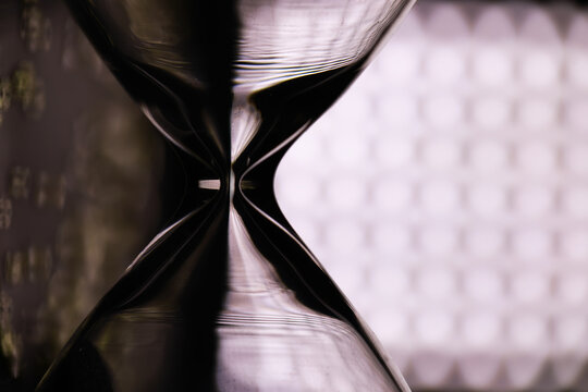 Close-Up of Hourglass with Abstract Reflection and Geometric Background