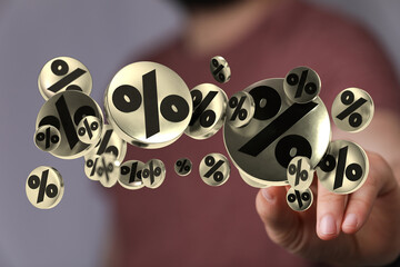Hand touching floating percentage symbols representing discounts, sales, investments, or financial...