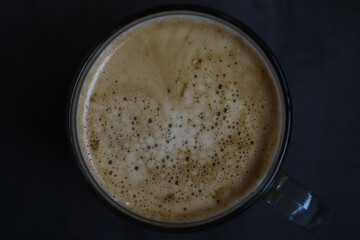 Top View of a Frothy Coffee Mug on Dark Background