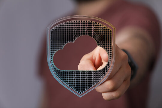 Hand pointing towards cloud security shield, representing data protection, privacy, and digital transformation. - Powered by Adobe