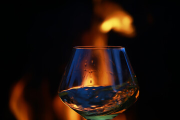 Close-Up of Glass Reflecting Warm Fireplace Ambience in Dark Setting
