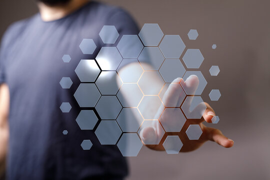Person interacting with a futuristic digital hexagon network concept, representing technology and innovation.