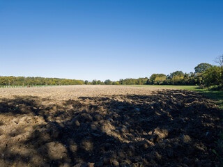 Countryside farmland with rich brown soil tilled for planting representing agricultural life and peaceful rural nature environment.