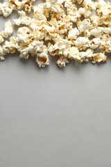 Vertical photo of popcorn on grey background. Top view, space for text