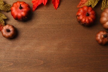 Beautiful autumn flat lay with pumpkins and leaves on wooden background. Thanksgiving greeting card design. Autumn fall