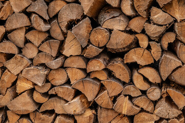 Wooden natural sawn logs as background, top view, flat lay. Wood texture. Firewood stack. 
