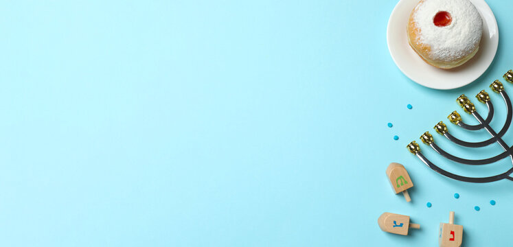 Happy Hanukkah greeting banner design. Flat lay with menorah, sufganiyot, dreidel set on blue background - Powered by Adobe