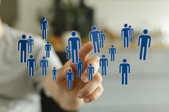 Hand pointing at human icons, representing virtual teamwork, and the concept of connection. Shows leadership an