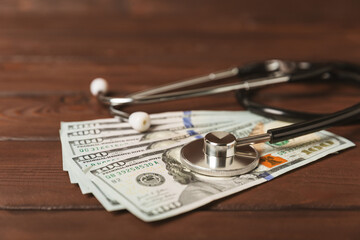 Medical costs, financial concept, health insurance. Stethoscope over dollar bills. Money and piggy bank. Medical care. Health care financial checkup or saving for medical insurance costs concept.