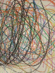 Abstract doodles made with colored pencils on old, yellowed paper. Multicolored strokes made with wax crayons.Creative background with tangled, colorful lines resembling children's drawings