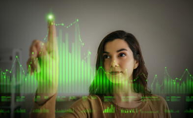 Businesswoman interacting with green digital graph for data visualization