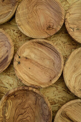 Handcrafted wooden plates displayed on a rustic wooden surface showcasing unique patterns and textures in an artisanal market setting