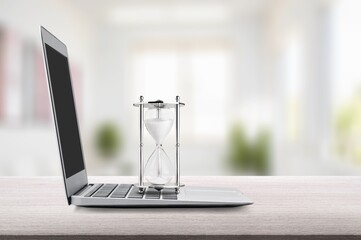 Hour glass on open laptop computer keyboard