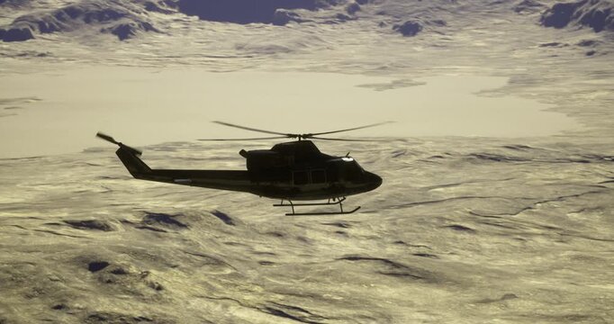 A helicopter navigates through a breathtaking snowy mountain range during sunset. The orange and purple hues of the sky contrast with the rugged terrain, creating a stunning view.