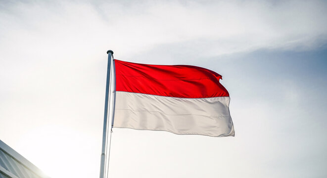 National flag of indonesia waving in the wind against a clear blue sky patriotism concept