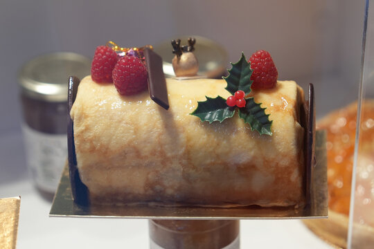 Traditional Christmas yule log cake with vanilla cream and raspberries - Powered by Adobe