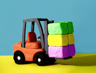 Clay forklift carrying colorful blocks on yellow surface with blue background, playful and creative miniature model