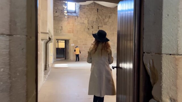 Mujer entrando a una estancia interior en el Castillo de Olite, Navarra