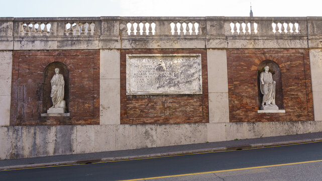 Statues placed in niches of brick wall near staircase of Quirinale Palace Italy. The plaque commemorates the improvement of access to Quirinal Hill carried out by the Senate and People of Rome in 1866