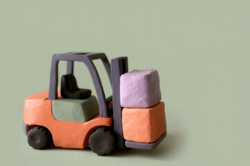 Fototapeta premium Clay forklift carrying colorful cargo boxes on plain background, creative and playful concept with soft pastel colors