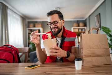 Delivery man enjoying a quick takeaway noodle lunch break