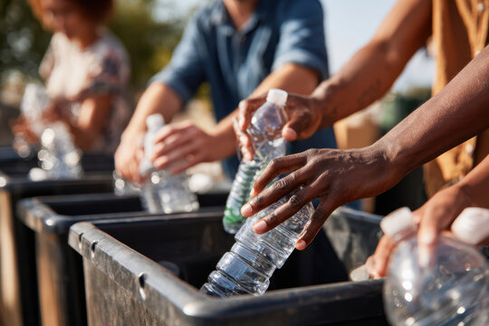 People recycling plastic bottles outdoors - Powered by Adobe
