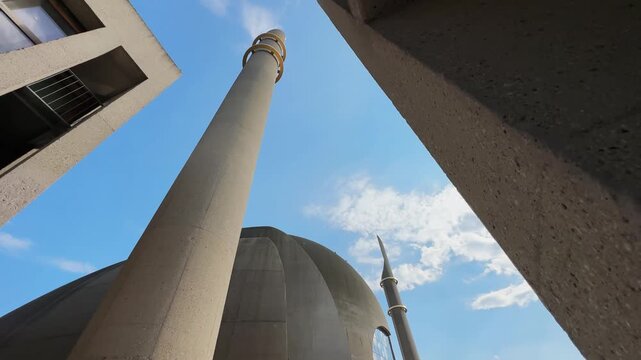 Minaret of the mosque in Cologne with the two golden rings against blue sky
