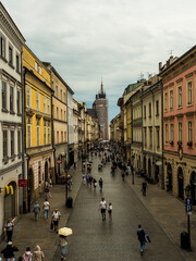 Obraz premium Transeuntes y turistas recorriendo una calle céntrica de Cracovia enuna mañana de lluvia (Cracovia, Polonia).
