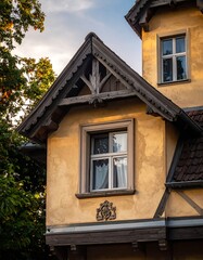 Close-up of a rustic building with ornate trim and windows, golden light