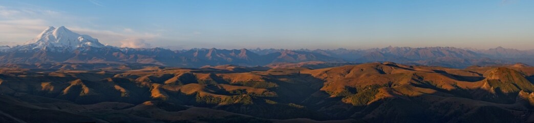 Russia, the Elbrus region. Stunning sunrise on the rocks of the Bolshoy Bermamyt plateau against the background of Mount Elbrus.