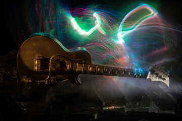 Music Concept: Guitar Miniature on a Dark Background with Vivid Light, Smoke, and Fire Effects. Golden electro guitar under a Dramatic Spotlight.