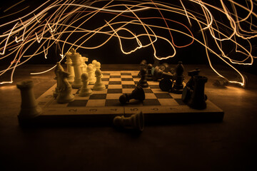 Chess board game concept of business ideas and competition. Chess figures on a dark background with smoke and fog.