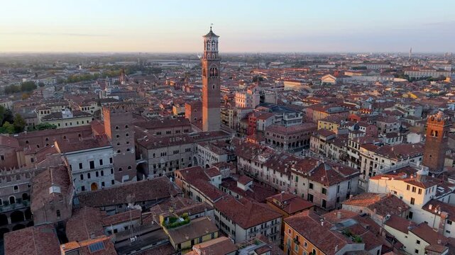 historic rooftops illuminated at dusk, dusk colors cast warm light on centuriesold riverfront. Verona. Italy