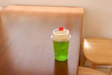 Melon soda float with vanilla ice cream and cherry on top in summer time,Melon soda is one of the most popular Japanese drink,Japanese cafe menu.