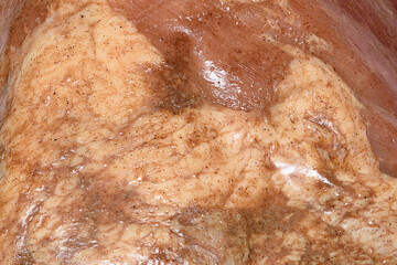 Close-up of the surface of a marinated piece of meat as a background or texture.