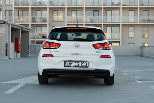Wroclaw, Poland - October 29, 2025: Rear view of a white Hyundai i30 parked on a rooftop parking area, displaying its taillights, badging and clean hatchback silhouette.