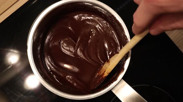 melting chocolate while stirring in a metal pot