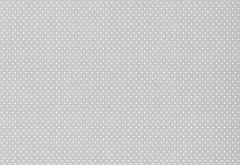 Gray paper with a pattern of small white polka dots arranged in a uniform grid. Minimalist design meant as background