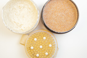 Three jars filled with body scrubs, featuring creamy and granular textures, placed on a clean surface, highlighting the importance of skincare and self-care routines