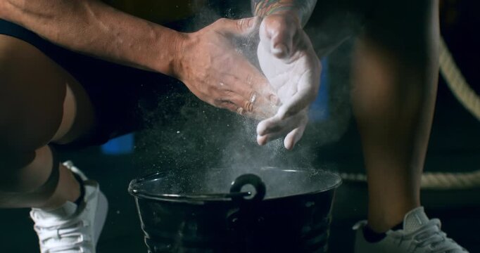 Slow Motion Macro Shot Of Chalk Covered Hands Dipping Into Gym Bowl And Creating White Dust Cloud Before Training Session At 1000 Fps.Concept Of Mental Preparation, Ritual, Strength, Athletic Crossfit
